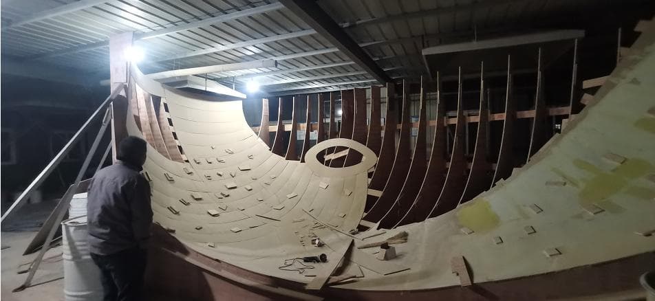 A curved custom mold under construction with shaped ribs and a lined surface