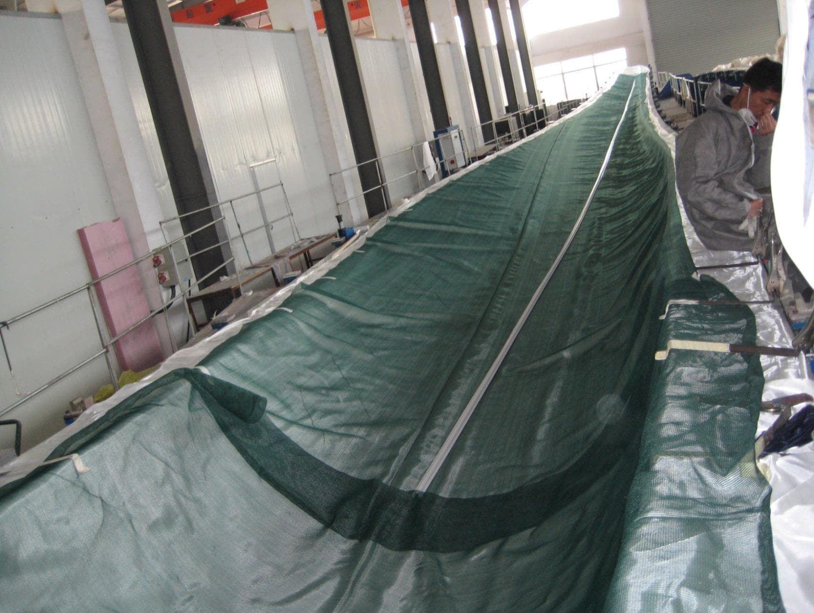 A curved composite mold with fiber layers, flow mesh and resin distribution tubing